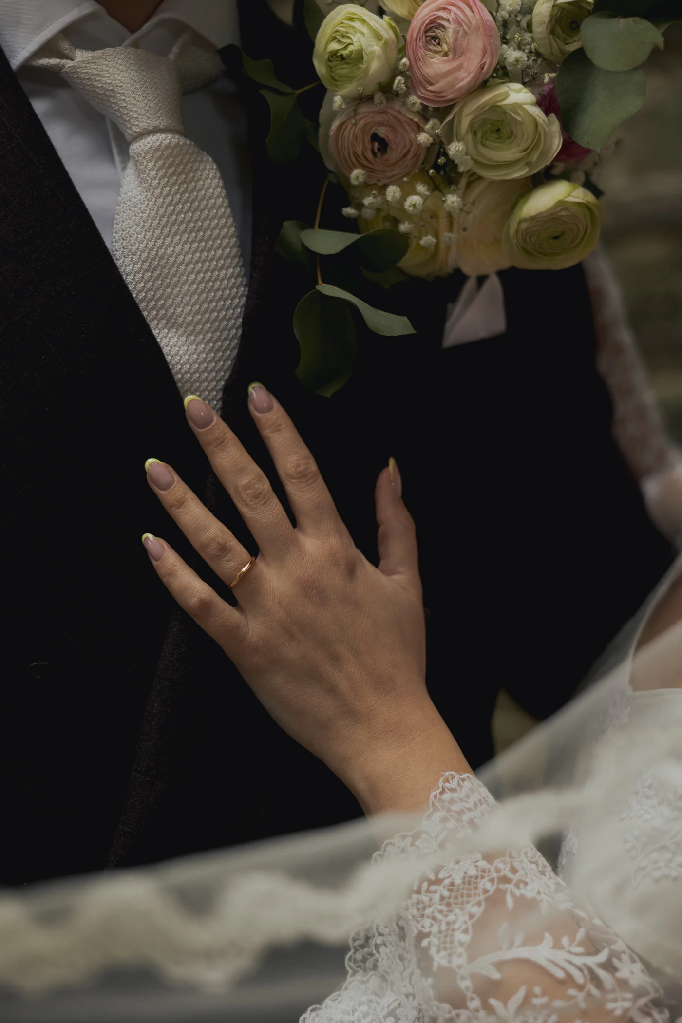 Détail de mariage — main de la mariée, alliance et bouquet — Joyce Martens Beauty